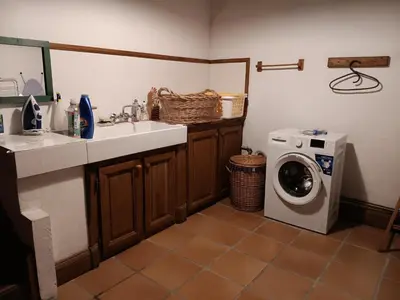 a kitchen with a sink and a washing machine at Maison de campagne avec lac privé in Fendeille