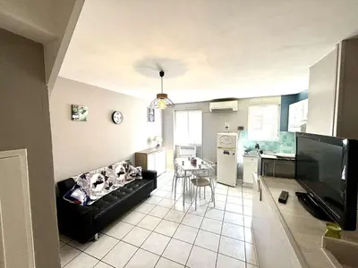 a living room with a couch and a kitchen at Appartement 3 pièces Port la Nouvelle PN000-151 in Port-la-Nouvelle