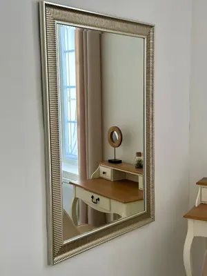 a gold framed mirror on a wall with a table at Douce parenthèse in Carcassonne