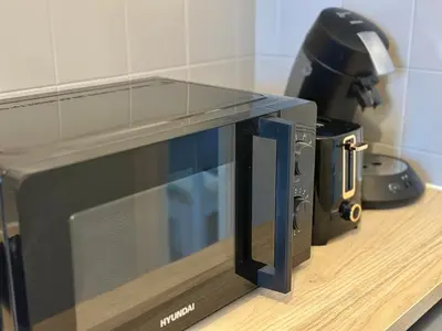 a microwave sitting on a counter next to a coffee maker at Douce parenthèse in Carcassonne