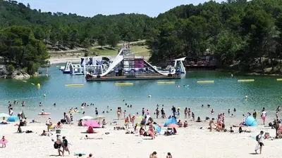 a group of people on a beach with a boat in the water at Douce parenthèse in Carcassonne
