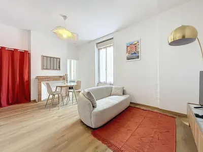 a living room with a couch and a table at Le Petit Sud - Appartement Proche des Halles - Wifi in Narbonne