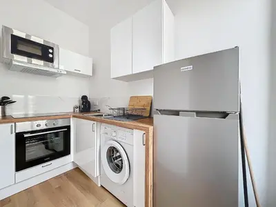 a kitchen with a refrigerator and a washing machine at Le Petit Sud - Appartement Proche des Halles - Wifi in Narbonne