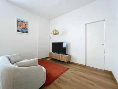 a living room with a couch and a television at Le Petit Sud - Appartement Proche des Halles - Wifi in Narbonne