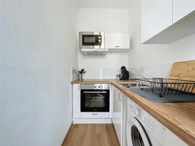 a kitchen with a stove and a microwave at Le Petit Sud - Appartement Proche des Halles - Wifi in Narbonne
