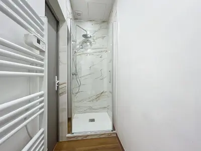 a bathroom with a walk in shower next to a toilet at Le Petit Sud - Appartement Proche des Halles - Wifi in Narbonne