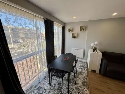 a living room with a table and a large window at Appartement Studio PORT LA NOUVELLE PN480-046 in Port-la-Nouvelle