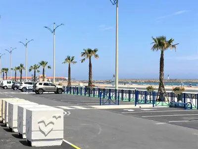 a parking lot at the beach with palm trees at Appartement Studio PORT LA NOUVELLE PN480-046 in Port-la-Nouvelle