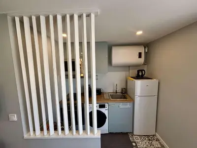 a small kitchen with a white railing next to a refrigerator at Appartement Studio PORT LA NOUVELLE PN480-046 in Port-la-Nouvelle