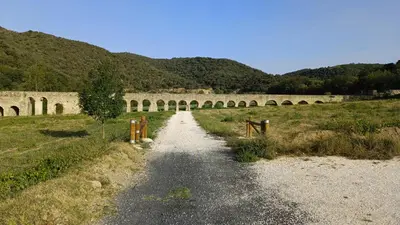 a dirt road with a bridge in the background at Vue D Ansignan in Ansignan