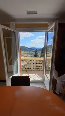 a room with a door open to a balcony with a view at Vue D Ansignan in Ansignan