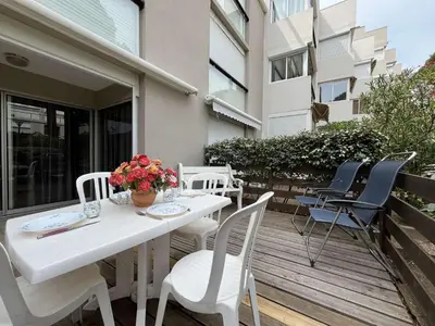 a white table and chairs on a wooden deck at Appartement Studio Cabine - proche plage du Grazel GN400-032 in Gruissan