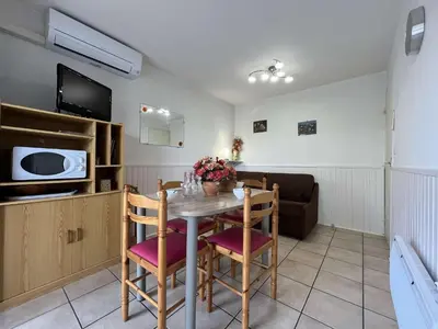 a kitchen and dining room with a table and chairs at Appartement Studio Cabine - proche plage du Grazel GN400-032 in Gruissan
