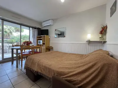 a bedroom with a bed and a table and a dining room at Appartement Studio Cabine - proche plage du Grazel GN400-032 in Gruissan