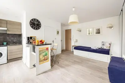 a bedroom with a bed and a kitchen with a sink at Aurore - Studio 1 in Carcassonne