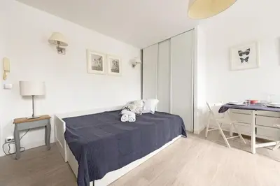 a white bedroom with a bed and a desk at Aurore - Studio 1 in Carcassonne