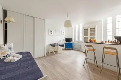 a living room with a couch and a kitchen at Aurore - Studio 1 in Carcassonne