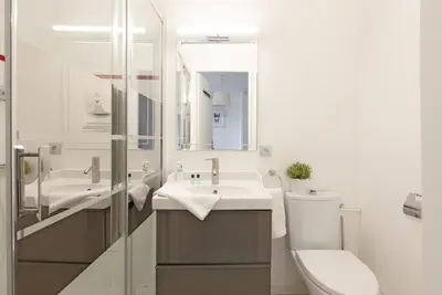 a bathroom with a sink and a toilet and a mirror at Aurore - Studio 1 in Carcassonne