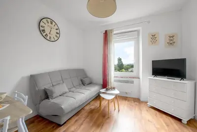 a living room with a couch and a clock on the wall at Aurora - T1 - 25 in Carcassonne