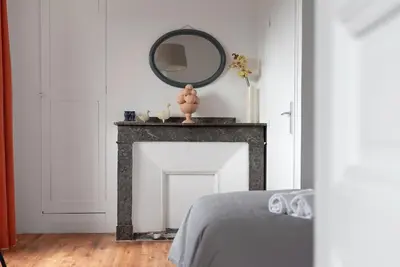 a bedroom with a fireplace with a mirror on it at Aurora - T1 - 25 in Carcassonne