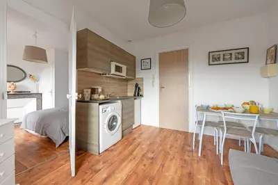 a room with a kitchen and a table with a washing machine at Aurora - T1 - 25 in Carcassonne