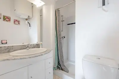 a white bathroom with a sink and a toilet at Aurora - T1 - 25 in Carcassonne