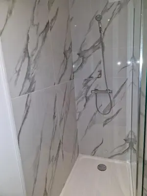 a bathroom with a shower with a glass door at village house in Villegly