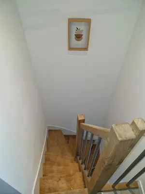 a wooden staircase with a picture on the wall at village house in Villegly