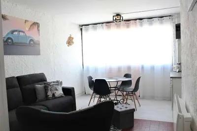 a living room with a couch and a table and chairs at Appartement Studio PORT LA NOUVELLE PN480-074 in Port-la-Nouvelle