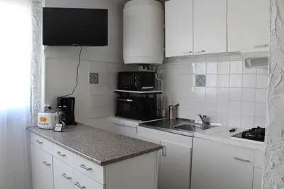 a kitchen with white cabinets and a sink and a microwave at Appartement Studio PORT LA NOUVELLE PN480-074 in Port-la-Nouvelle