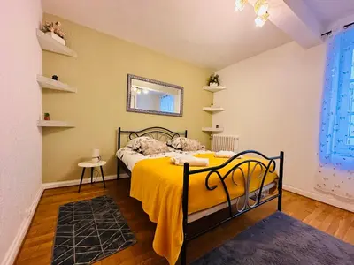 a bedroom with a bed with a yellow blanket at La Citadine in Carcassonne