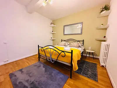 a bedroom with a yellow bed and a mirror at La Citadine in Carcassonne