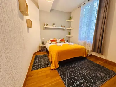 a bedroom with a bed with a yellow blanket at La Citadine in Carcassonne
