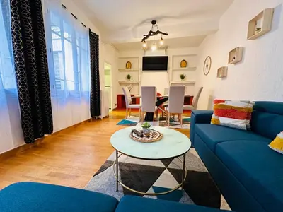 a living room with a blue couch and a table at La Citadine in Carcassonne