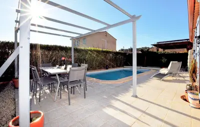 a patio with a table and chairs next to a pool at Nice Home In Lézignan-Corbières in Lézignan-Corbières