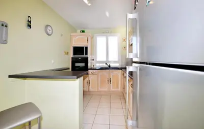 a kitchen with a stainless steel refrigerator and cabinets at Nice Home In Lézignan-Corbières in Lézignan-Corbières