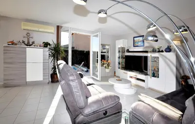 a living room with two chairs and a television at Nice Home In Lézignan-Corbières in Lézignan-Corbières