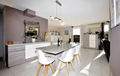 a kitchen with a table and white chairs at Nice Home In Lézignan-Corbières in Lézignan-Corbières