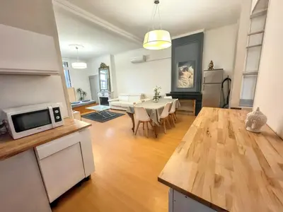 a kitchen and living room with a table and a couch at Appartement spacieux à Narbonne de 93 m² in Narbonne