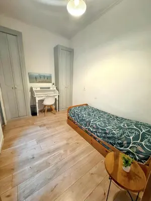 a bedroom with a bed and a desk and a piano at Appartement spacieux à Narbonne de 93 m² in Narbonne