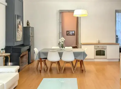 a living room with a table and white chairs at Appartement spacieux à Narbonne de 93 m² in Narbonne