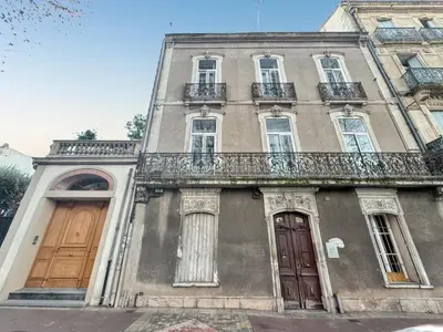 an old building with two doors and a balcony at Appartement spacieux à Narbonne de 93 m² in Narbonne
