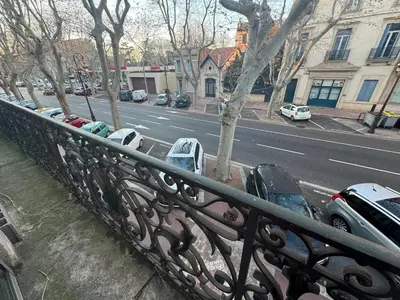 a balcony with cars parked on a city street at Appartement spacieux à Narbonne de 93 m² in Narbonne