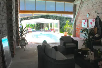 a living room with a swimming pool in a house at La Ferme de Bellune in Mazères
