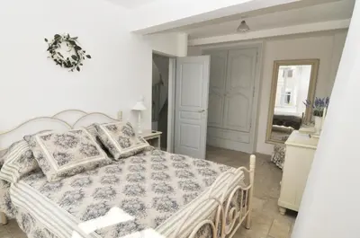 a bedroom with a large bed and a mirror at Chez LuLu Holiday Home in Olonzac