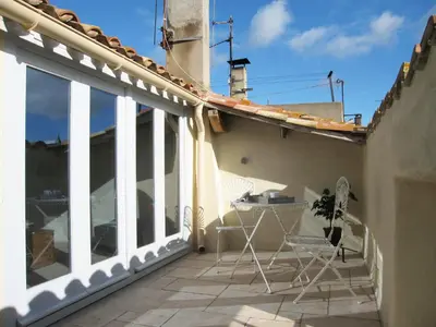 a balcony with chairs and a table on a house at Chez LuLu Holiday Home in Olonzac