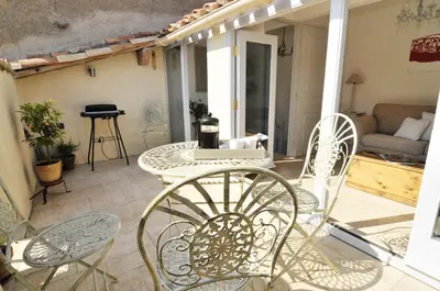 a patio with a table and chairs and a couch at Chez LuLu Holiday Home in Olonzac