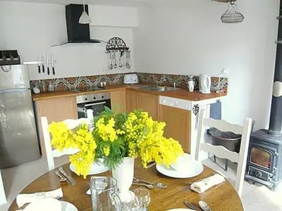 a kitchen with a table with yellow flowers on it at Chez LuLu Holiday Home in Olonzac
