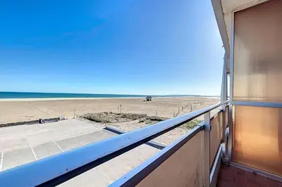 a view of the beach from the balcony of a house at Charming T2 with terrace on the seafront in Port-la-Nouvelle