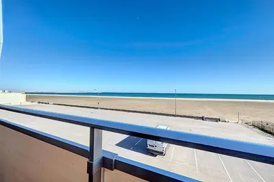 a view of the beach from the balcony of a building at Charming T2 with terrace on the seafront in Port-la-Nouvelle
